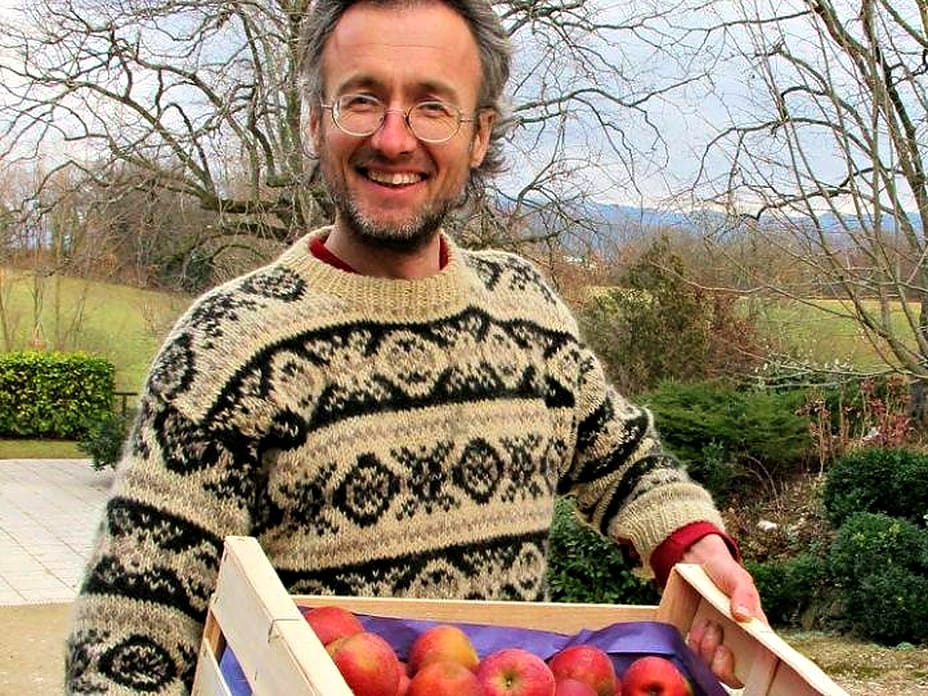 Jean-François Chosson, du Verger Saint-Martin, porte une cagette de pommes dans son verger