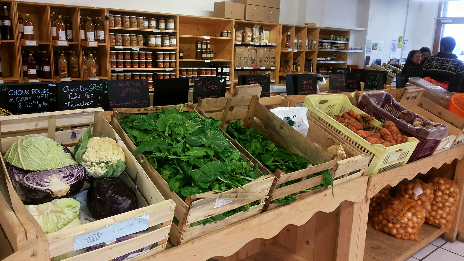 Cagettes de choux, d'épinards et de carottes sur l'étal en bois du magasin